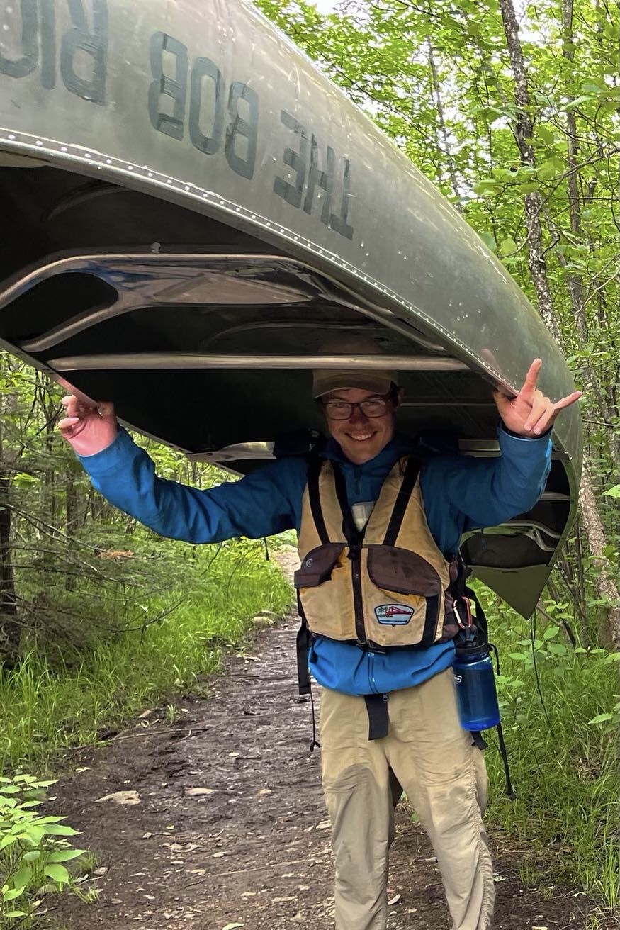 John DeGonda portaging a canoe